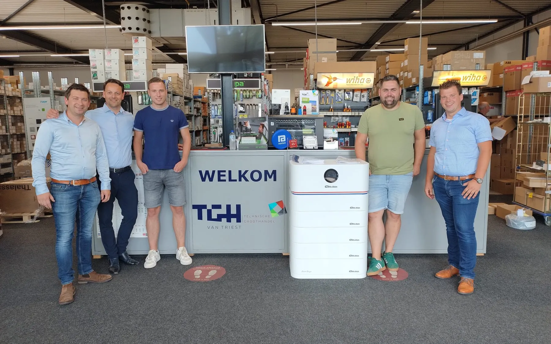 Het team van Altilia en de groothandel aan de welkomstbalie, met een Altilia stapelbatterij in het midden