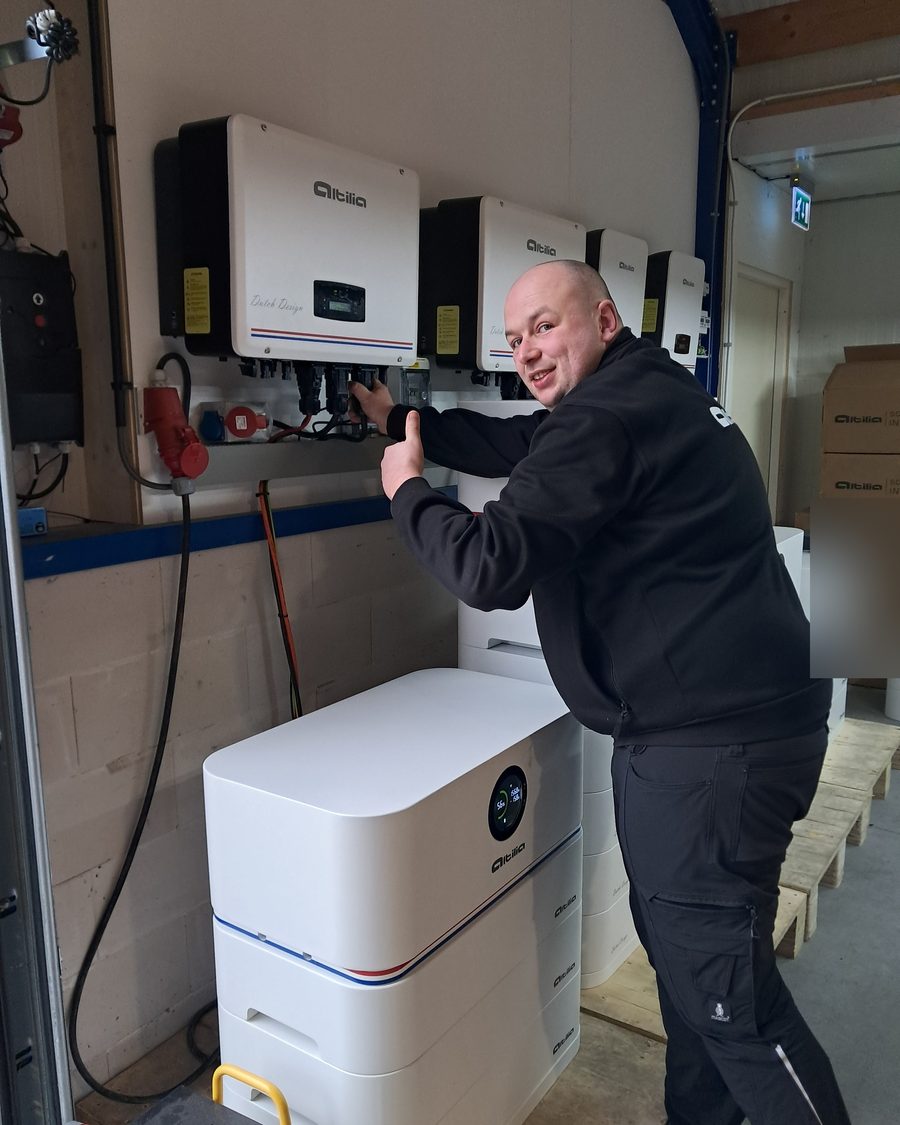 Technicus van Altilia steekt zijn duim op bij een testopstelling met batterijen en omvormers in Renswoude