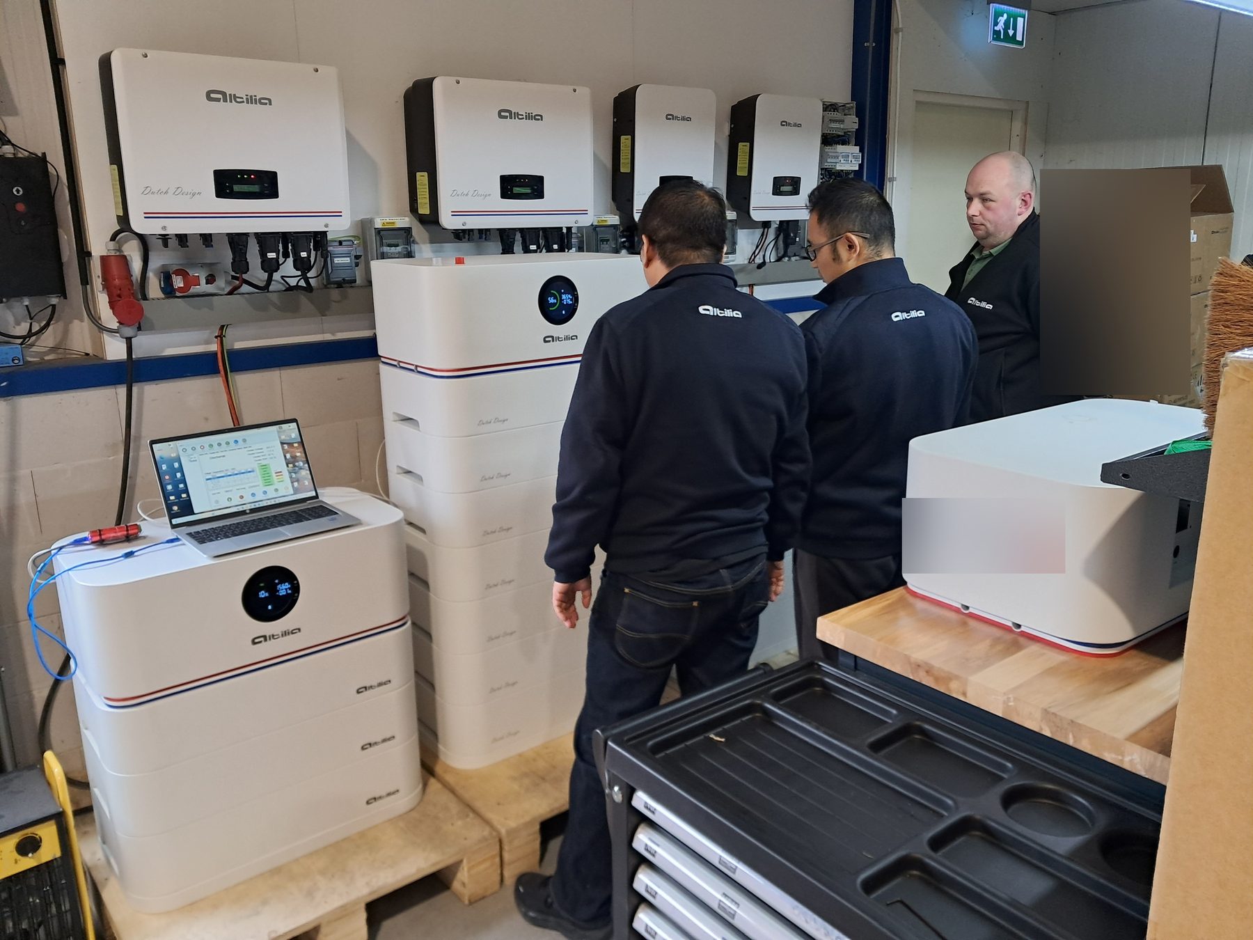 Medewerkers in het testcentrum in Renswoude bij Altilia-batterijen en omvormers, met een laptop op een testopstelling